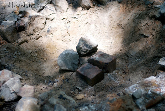 Cast iron dutch oven buried in coals and rocks for slow cooking beef à la mode outdoors