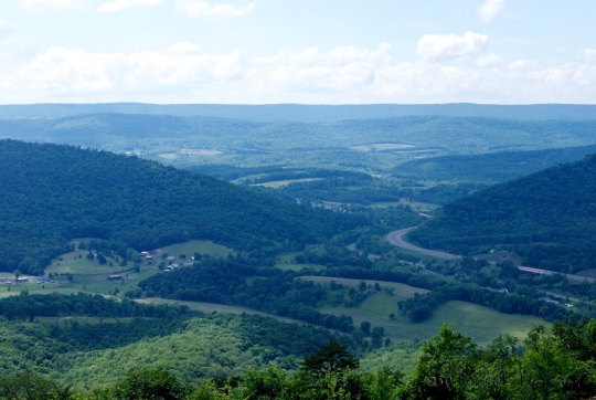 Scenic valley landscape with forested mountains and winding river.  outdoor cooking adventures