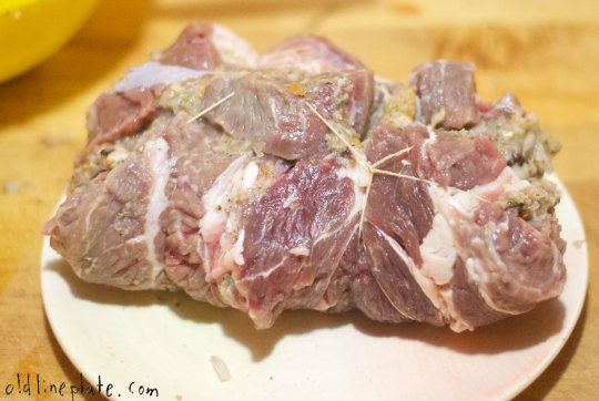 Raw beef chuck roast tied up on white plate for Beef à la Mode recipe preparation