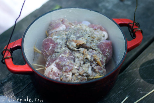 Raw beef coated with seasonings in red Dutch oven for beef à la mode