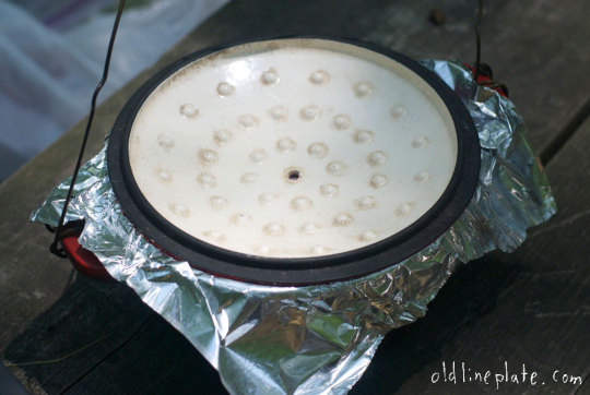 Dutch oven lid with coals for outdoor slow cooking beef à la mode using underground heat method