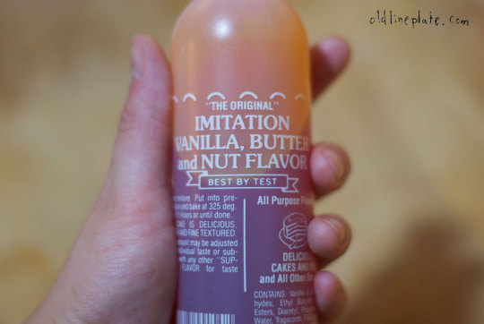 Hand holding bottle of The Original imitation vanilla, butter and nut flavor extract for baking pound cake
