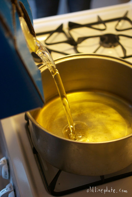 Golden oil pouring into pot for frying Fastnachts Küchlie, traditional Lenten pastries known as kinklings