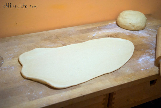 Freshly rolled out dough for fastnachts on wooden surface before frying