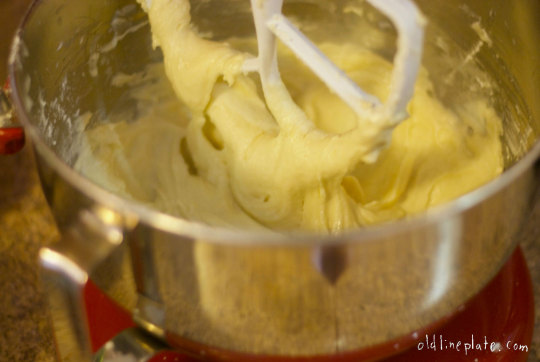 Close-up of electric mixer beating pale yellow Silver Cake batter in metal bowl
