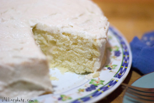 Slice of classic Silver Cake with white frosting on decorative blue-rimmed plate