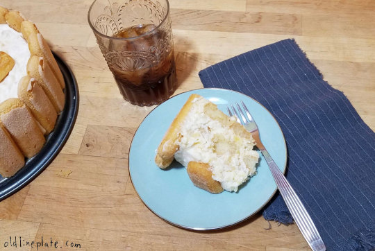 Slice of pineapple icebox cake with whipped cream on blue plate, served with iced coffee