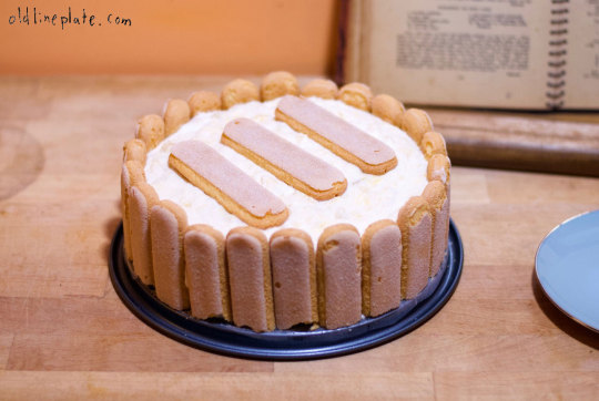 Homemade pineapple icebox cake with ladyfinger cookies and whipped cream topping on blue plate