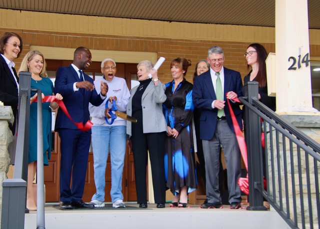 (Rick Miller/Olean Star) Della Moore (center with scissors) reacts after cutting the ribbon Wednesday to open the new African American Center for Cultural Development at 214 N. Barry St., Olean.