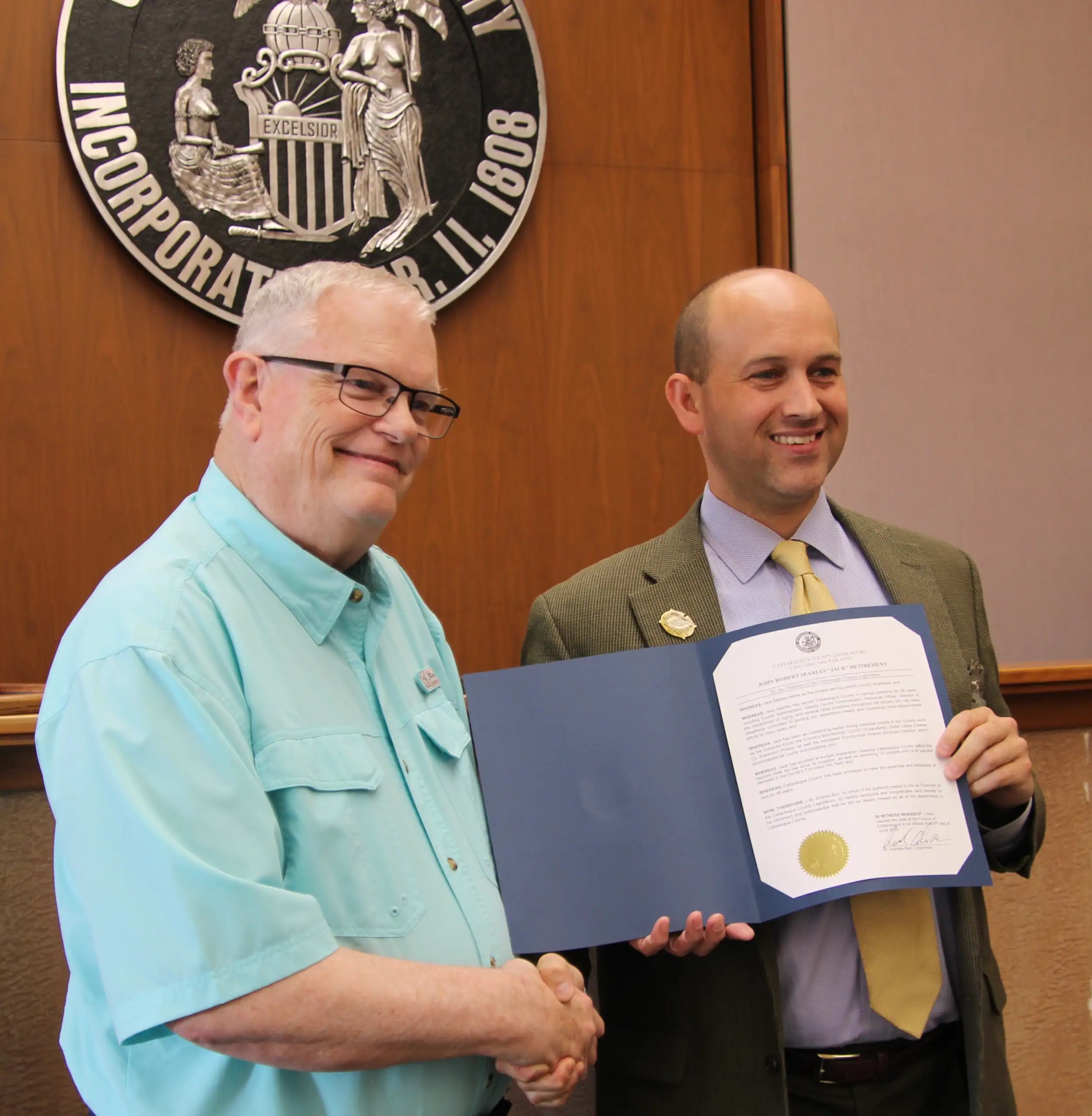 (Rick Miller/Olean Star) Cattaraugus County administrator Jack Searles (left), is received a citation Wednesday from County Legislature Chairman Andrew Burr, R-Gowanda, on his retirement after 22 years in the post.