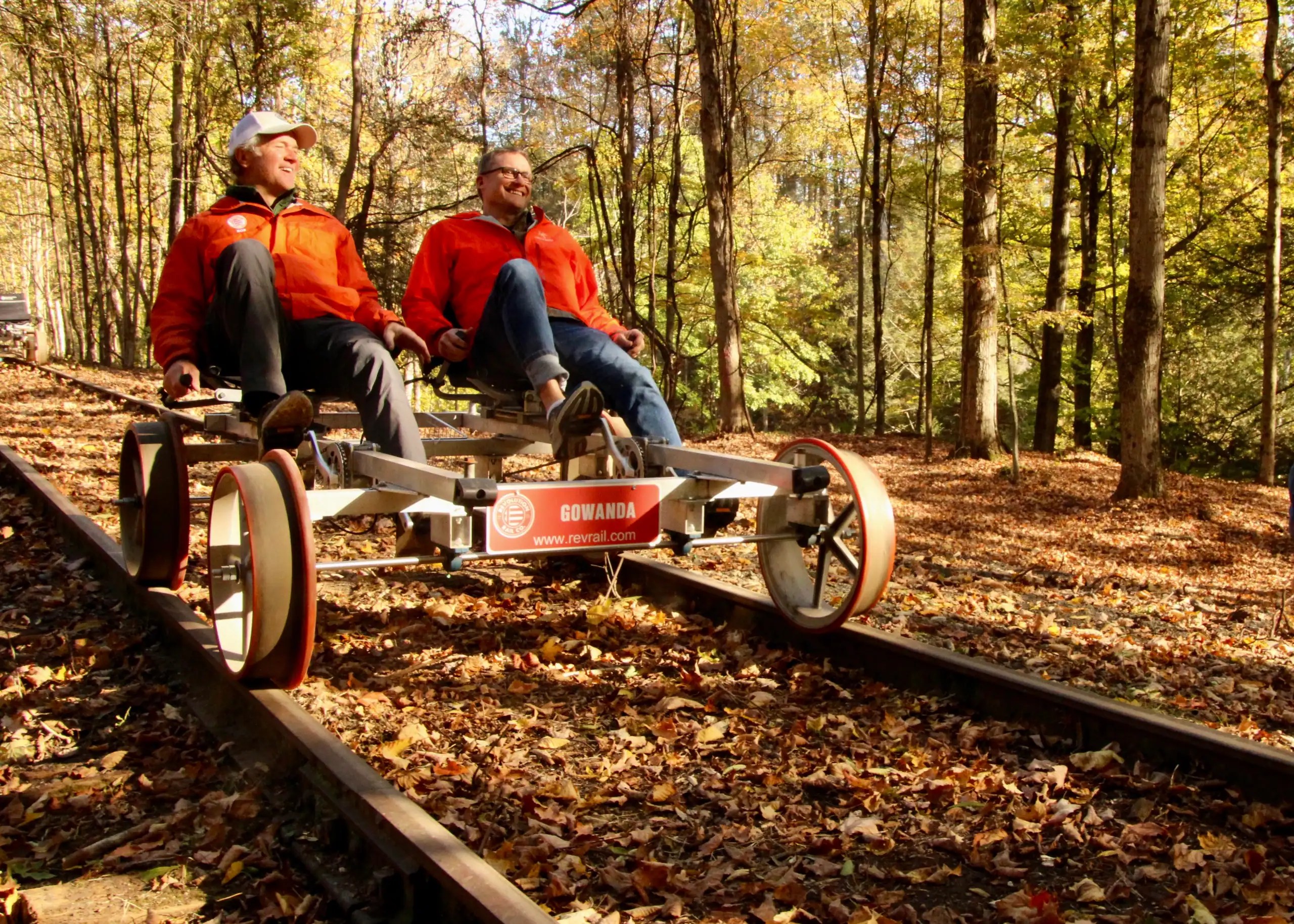 (Rick Miller/Olean Star) Revolution Rail CEO Rob Harte (left) and Rocketcup Coffee CEO Tom Cullen ride a rail bike along railroad tracks of the former Erie Railroad near Cattaraugus Thursday. There will be pop-up rail bike rides on the next three weekends in Cattaraugus.