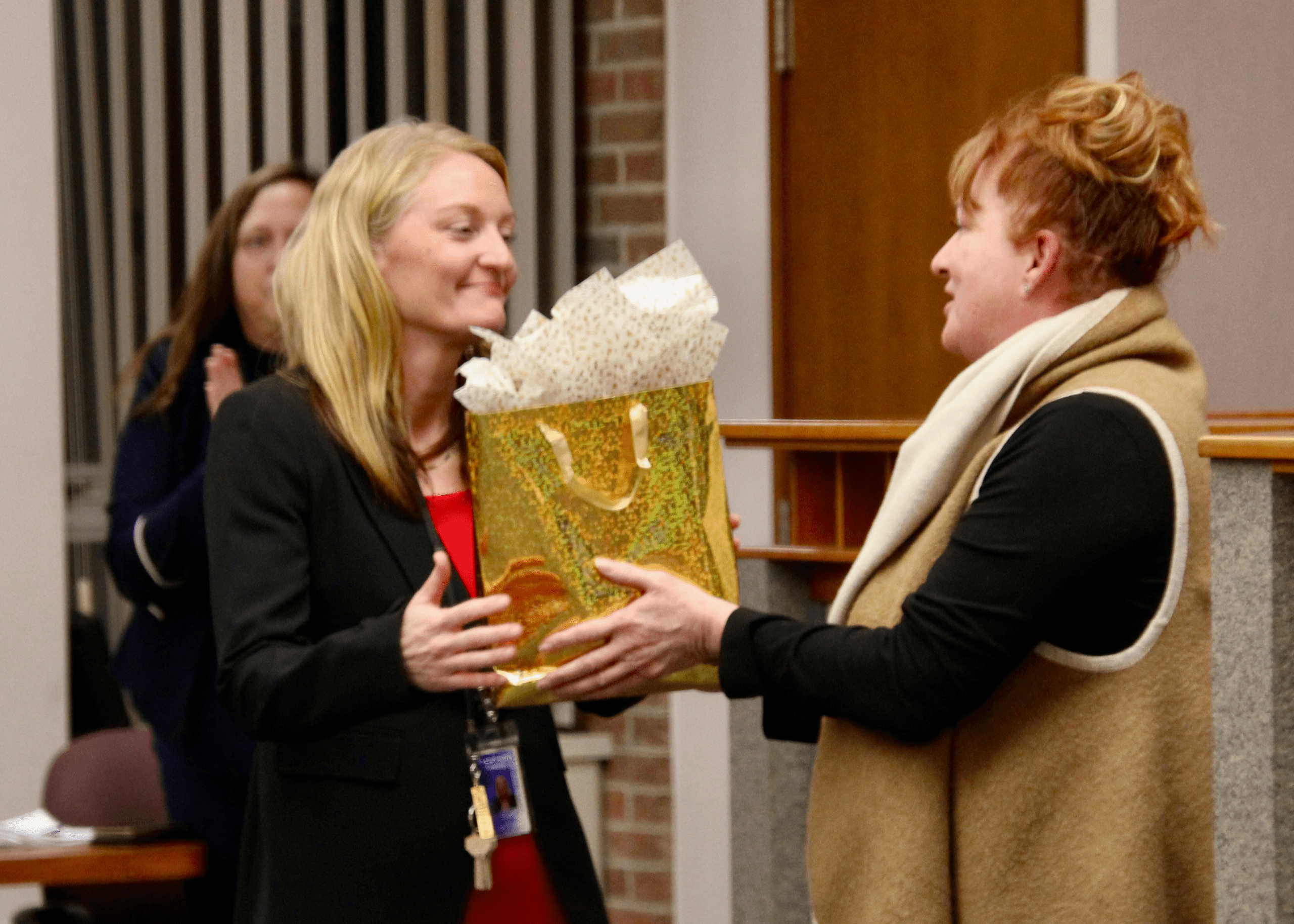 (Rick Miller/Olean Star) Ashley Smith (left), who was sworn in Wednesday as the new Cattaraugus County district attorney, receives a gift from County Legislator Ginger Schroder on Dec. 10 for her service as county attorney.