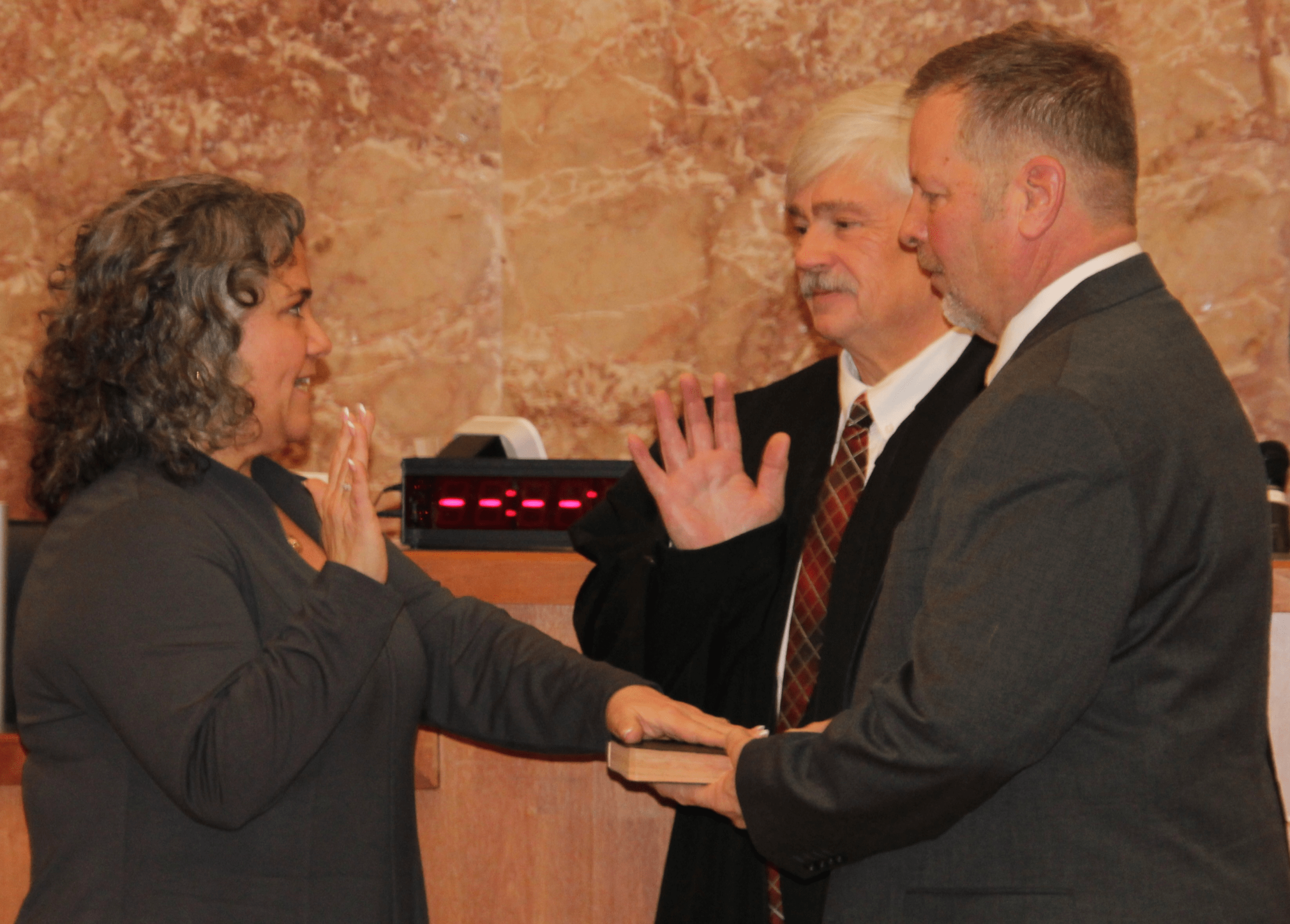 (Rick Miller/Olean Star) Olean Mayor Amy Sherburne takes the oath of office Friday from Cattaraugus County Court Judge Ronald D. Ploetz. Her husband, Bob, holds the Bible.