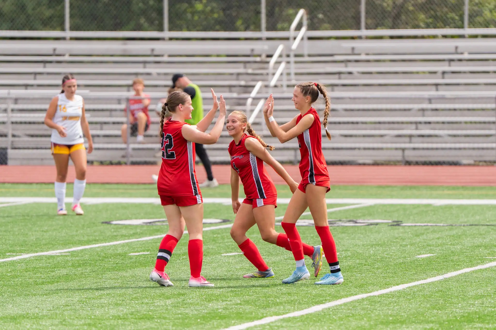 Bradford's Alexis Kicior (left to right), Karissa Chamberlain and Alyssa Mangold celebrate after taking a 2-0 advantage in the Lady Owls' win over Elk County Catholic. | Photo by Hunter O. Lyle