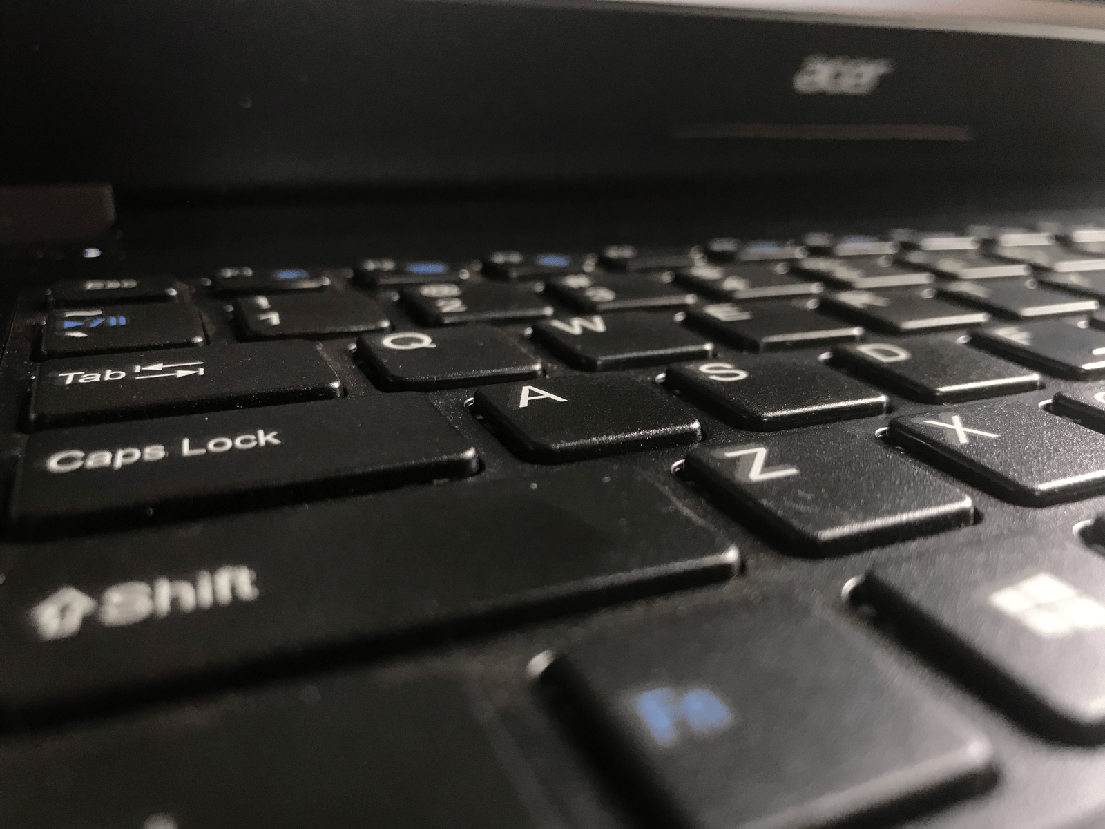 Close-up of a black laptop keyboard with the Caps Lock key and the Shift key below it in focus.