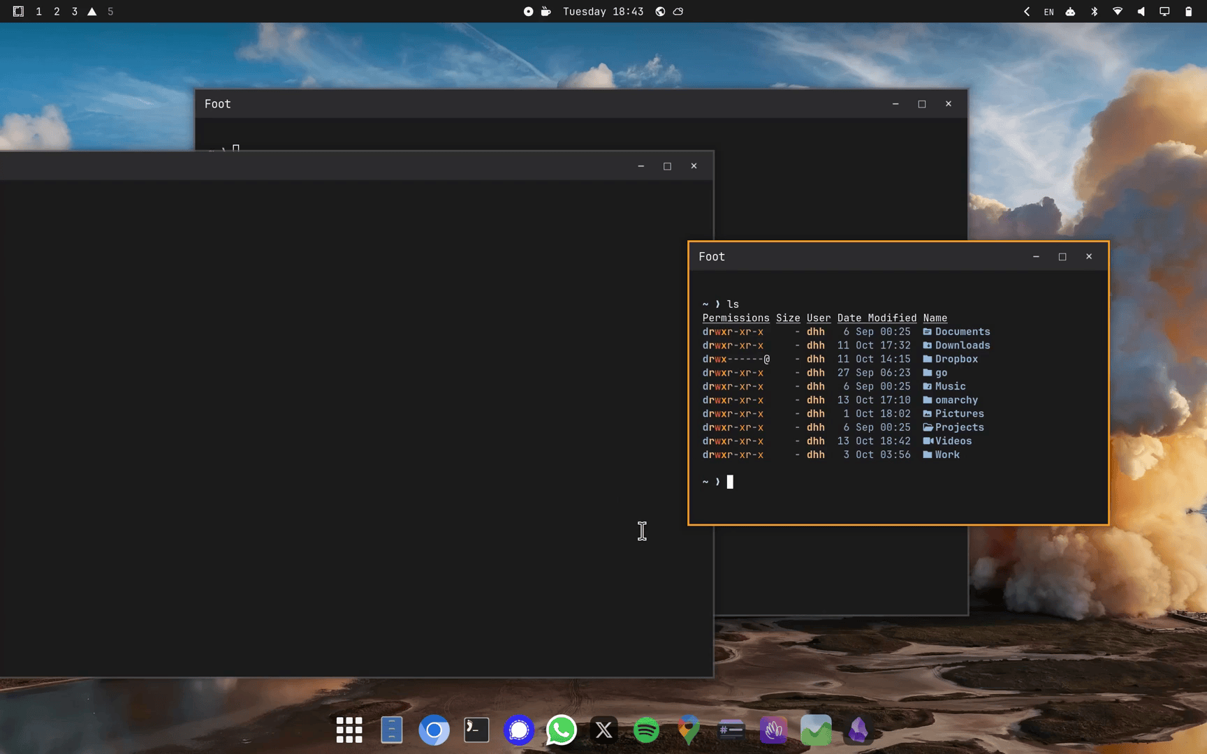 Omarchy in traditional desktop mode, with floating windows over a wallpaper and an app dock along the bottom of the screen.