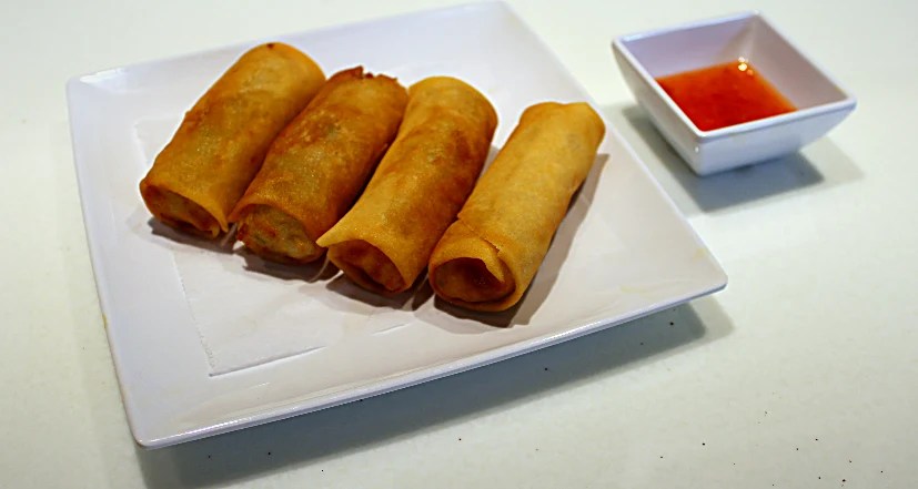 Four crispy golden egg rolls with sweet chili dipping sauce