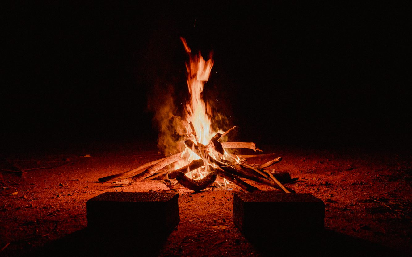 Campfire burning brightly at night.