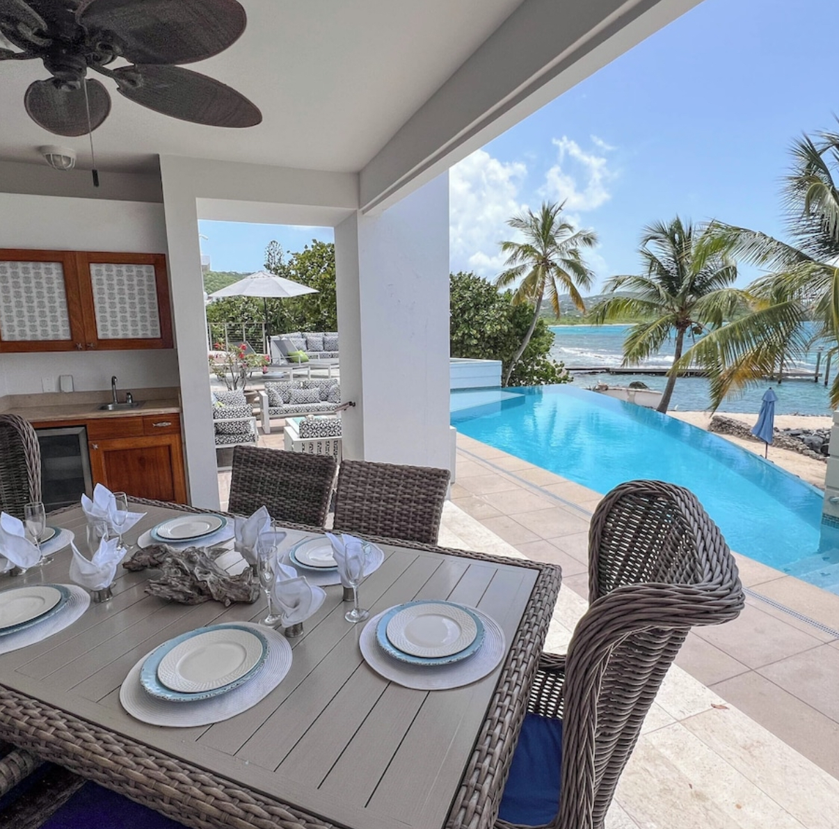 Covered outdoor dining area above pool