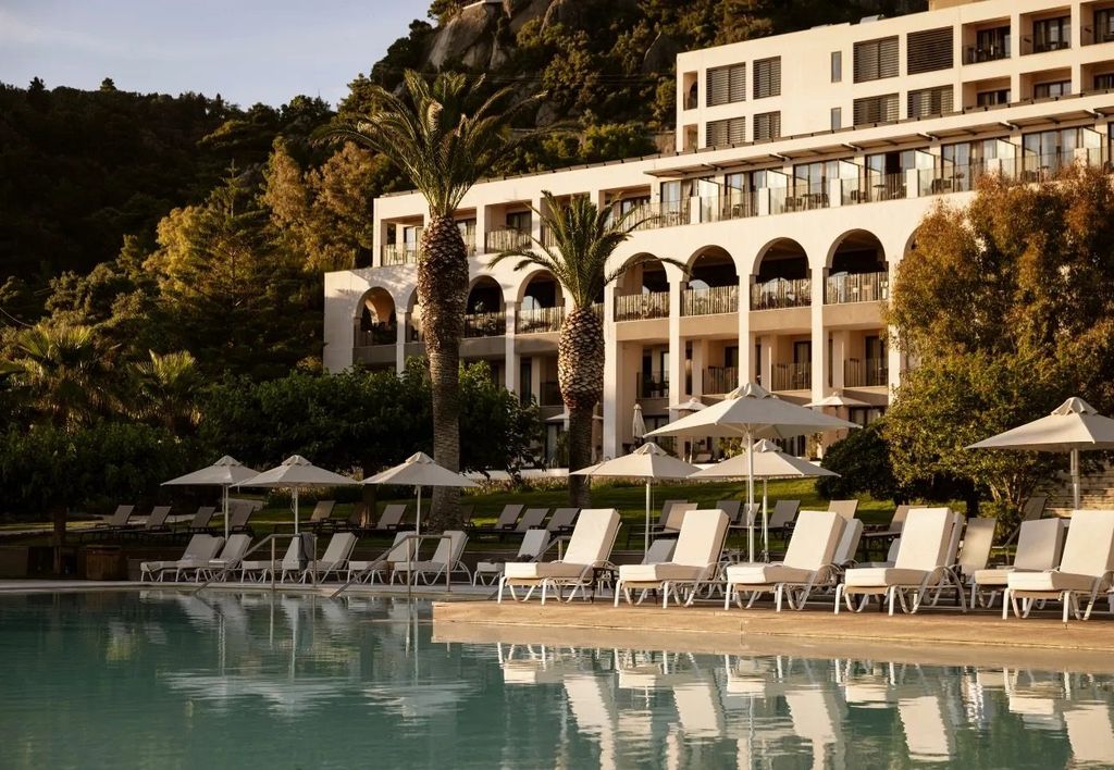 Pool terrace with arched architecture at Domes of Corfu, overlooking the Corfu hillside