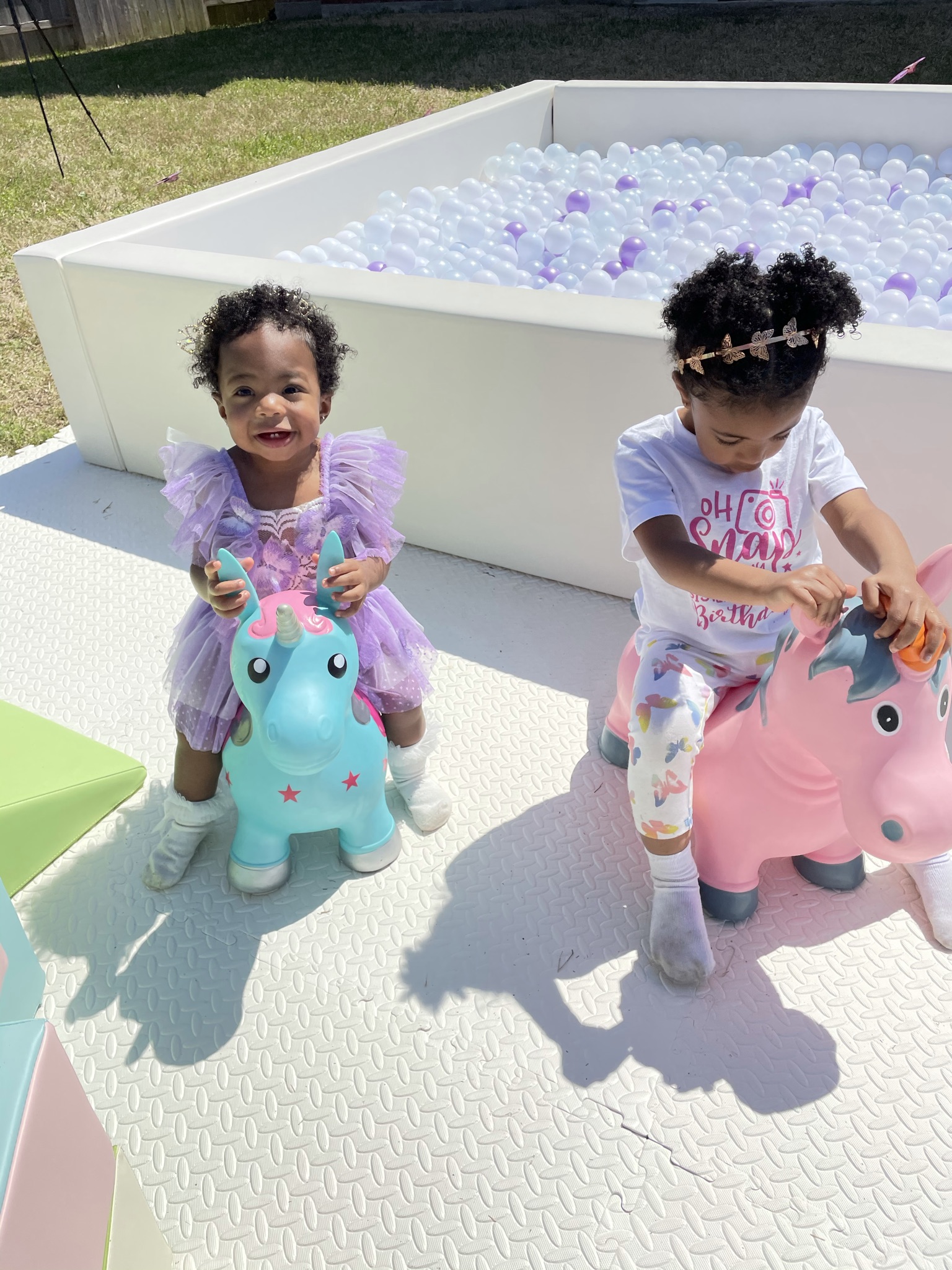 the birthday girl and her sister playing with the soft play equipment with big smiles