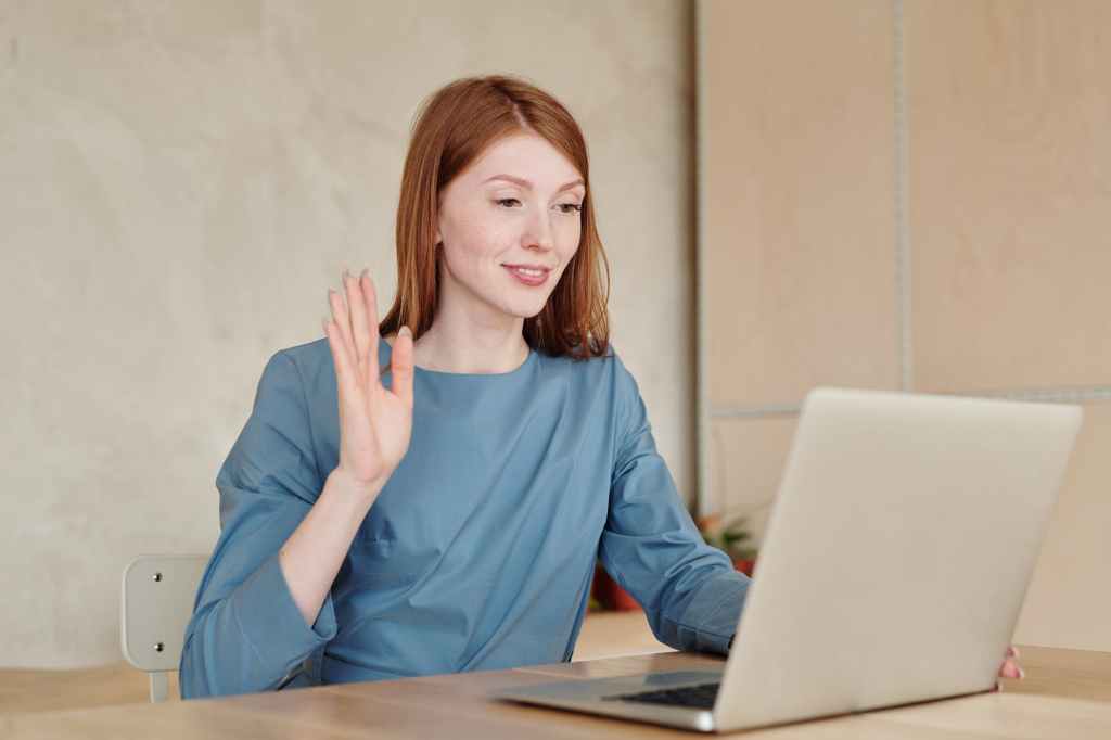 woman in blue long sleeve shirt sitting by the table