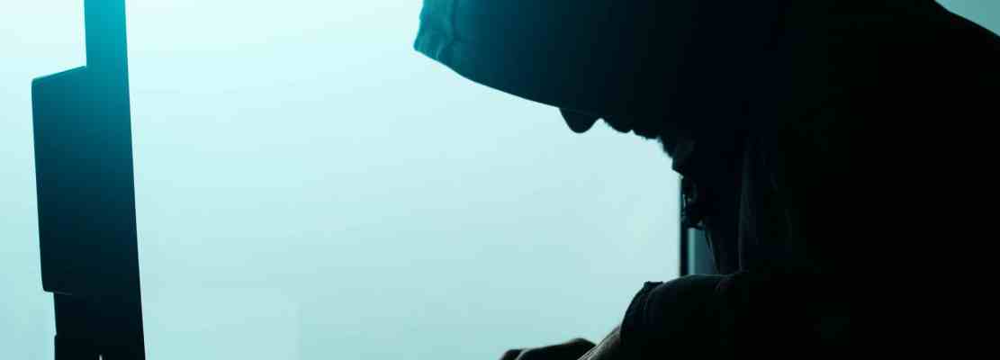 Hooded computer hacker hacking network