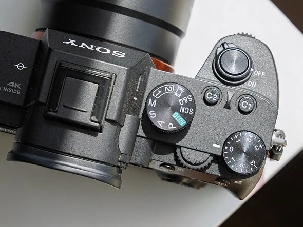 A camera is on a white desk with harsh lights