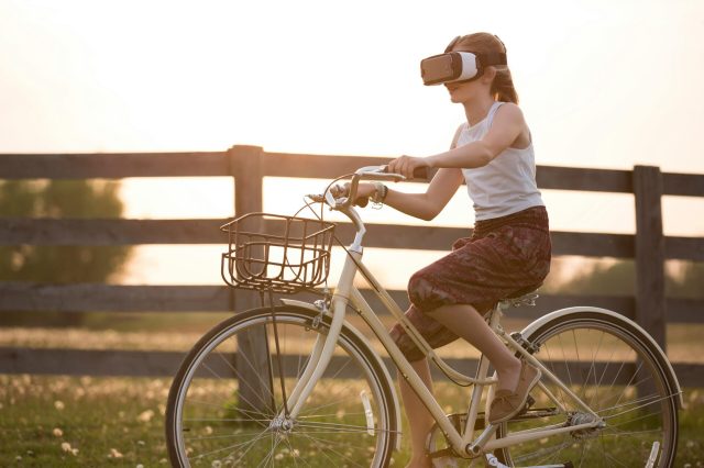 MÃ¤dchen, Das Vr Box Fahrendes Fahrrad WÃ¤hrend Der Goldenen Stunde TrÃ¤gt