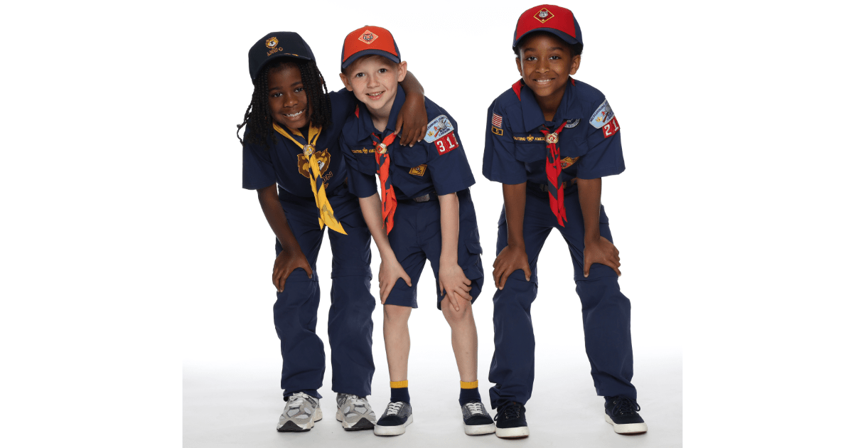 A photo of three Cub Scouts, each of whom are very excited to join Scouting