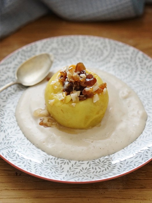 Bratapfel in der Mikrowelle gegart mit Vanillesoße auf einem Teller
