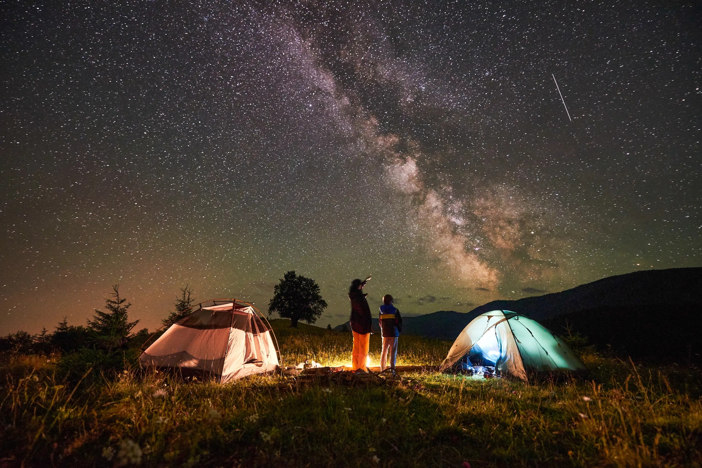 Tents lit up under a starry night sky on the Oregon Coast