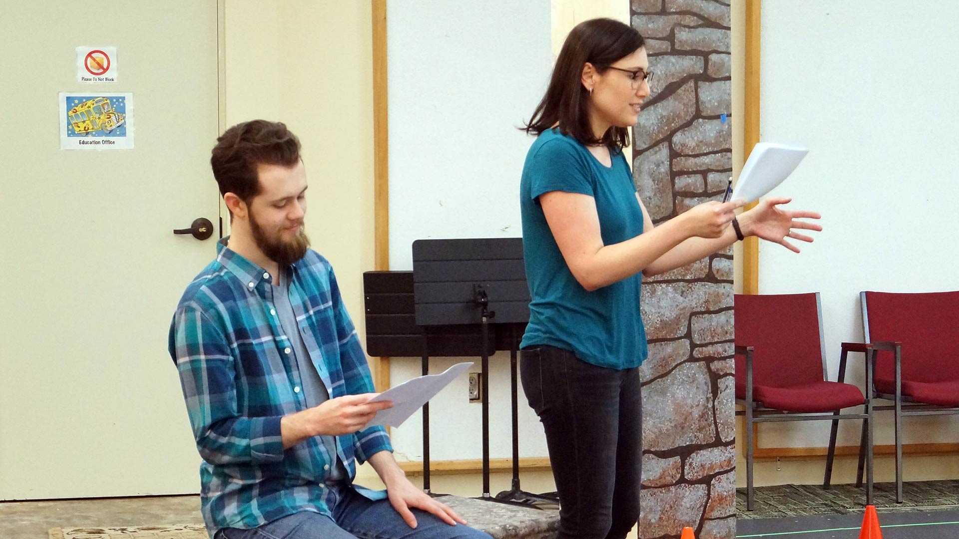 Actors Amy Hutchins and Daniel Roth read from their scripts.