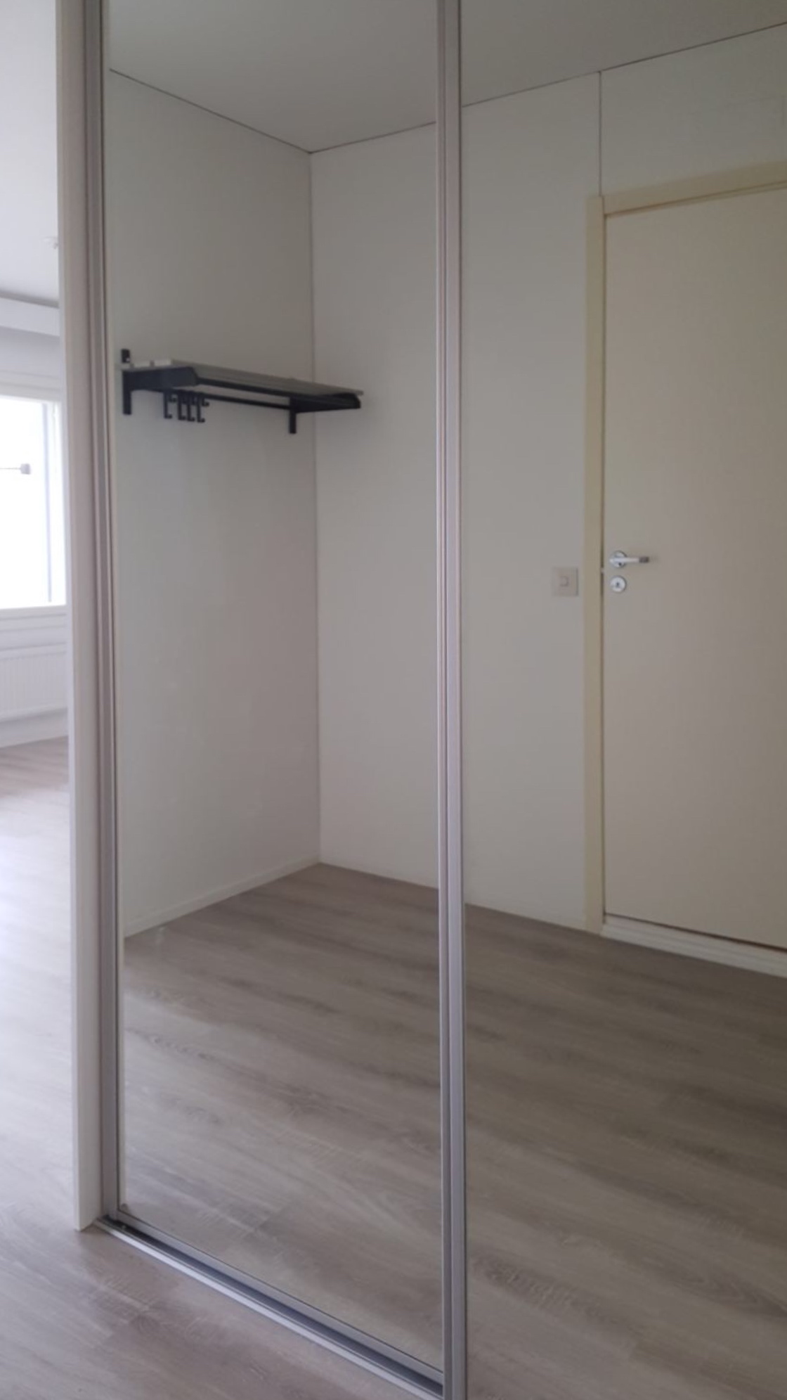 Asunnon ovelta päin, kylpyhuoneen ovi näkyy peilistä