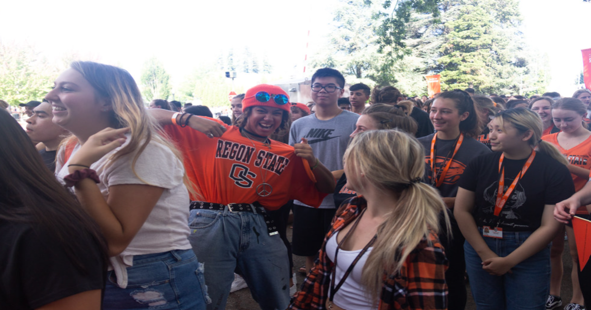 Group of Oregon State University students smiling and showing school spirit