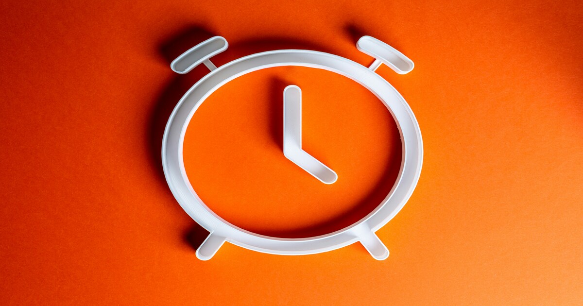 Silhouette of an alarm clock with an orange background