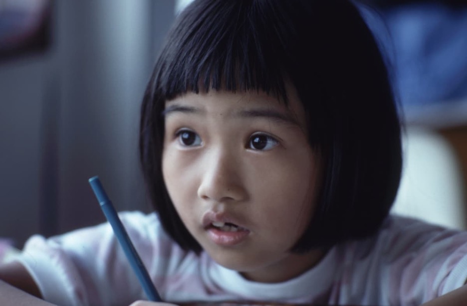 A young child holding a pen