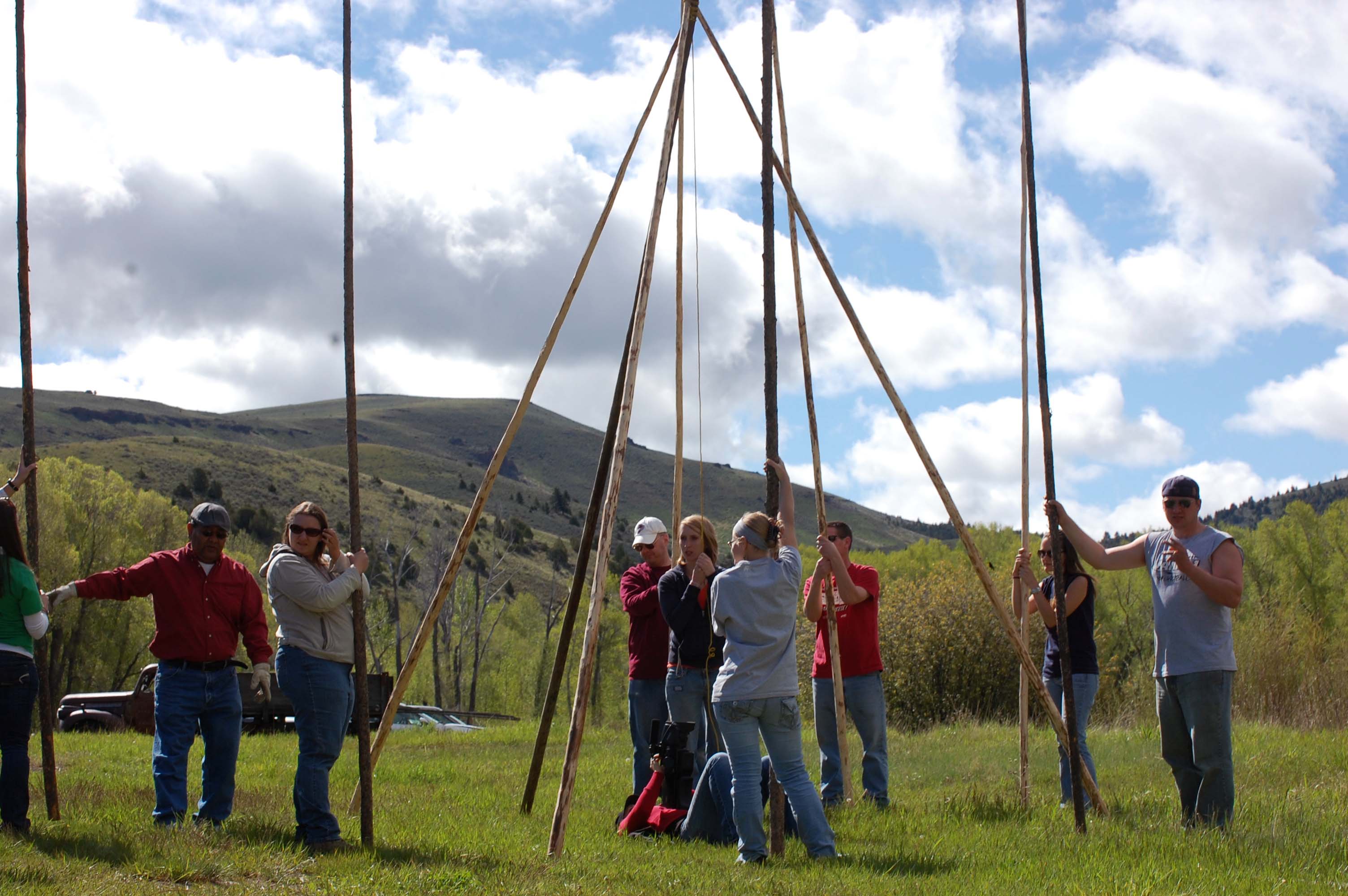 Students learning to build a tipi
