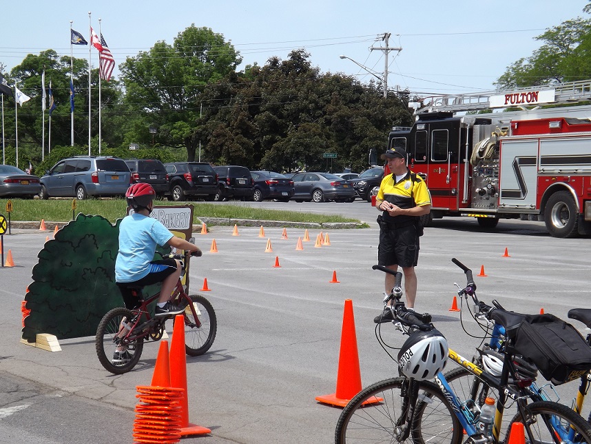 A Fulton Police Bike Officer teaches a young rider before guiding him through the obstacle course.