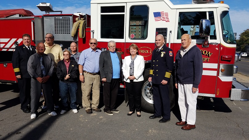 Chief David Eiffe, Assistant Chief Shane Laws, Mayor Ronald Woodward Sr. and members of the Fulton Common Council stand with Senator Patty Ritchie in front of the ladder truck purchased with grant funding secured by Ritchie.