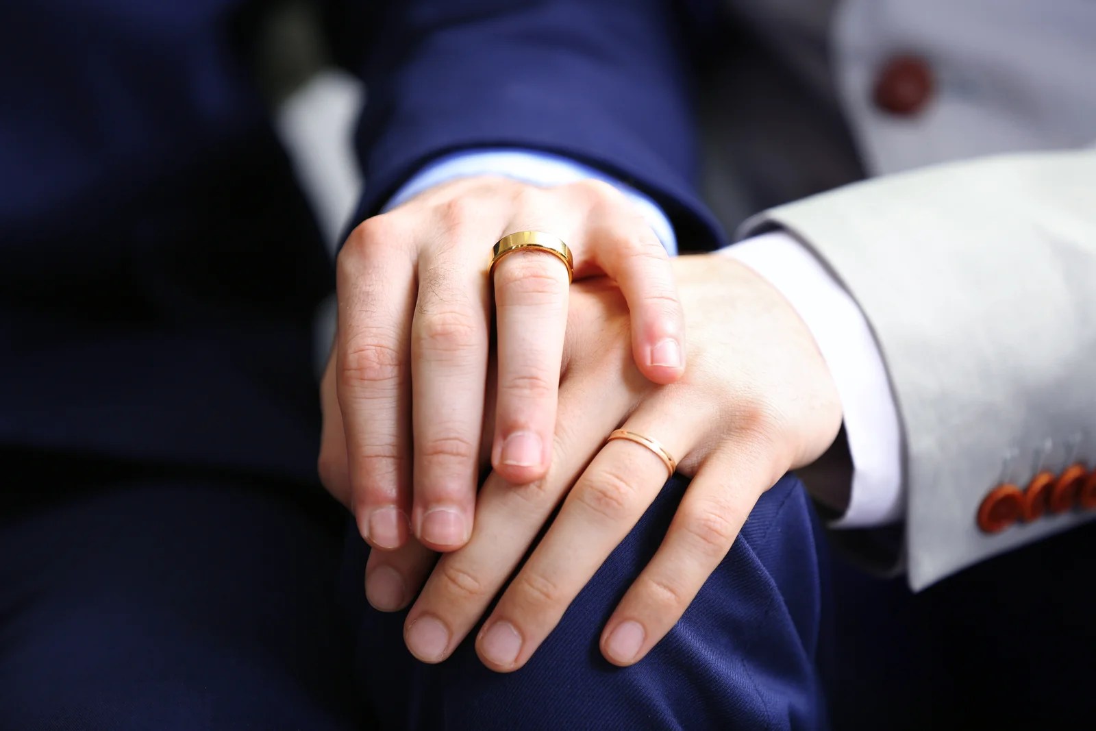 Couple homosexuel se tenant la main avec leurs alliances