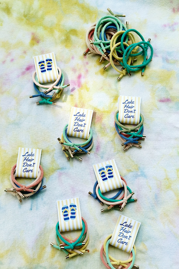 Several completed Lake Hair Don't Care printable hair tie favors showing the front and back designs, including a flip-flop pattern on the reverse side.