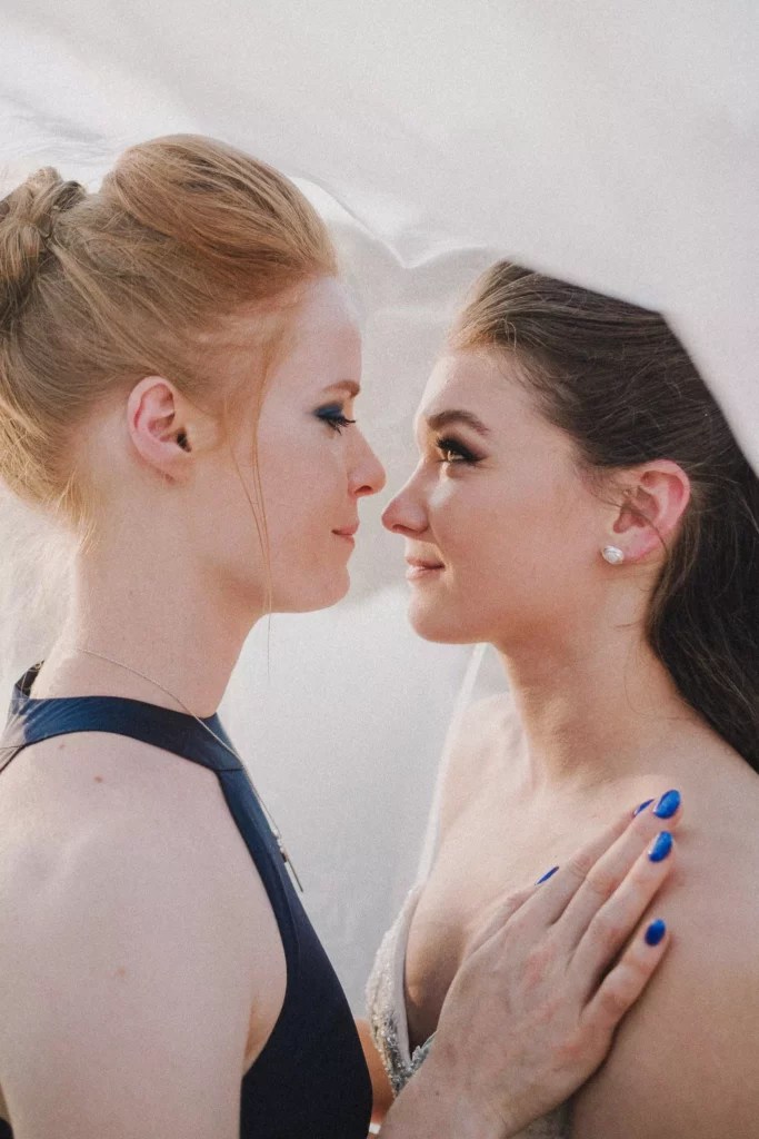 Photographe mariage Éghezée – regard complice entre la mariée et sa demoiselle d’honneur sous un voile