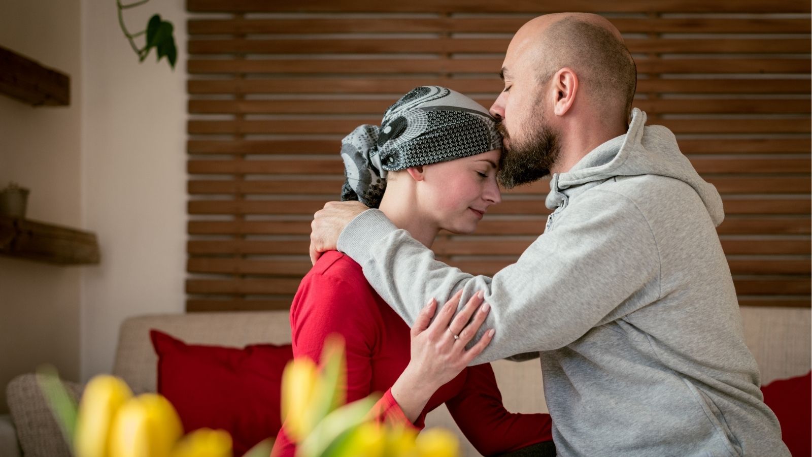 Ovarian cancer survivor embraced and reassured by spouse with a kiss