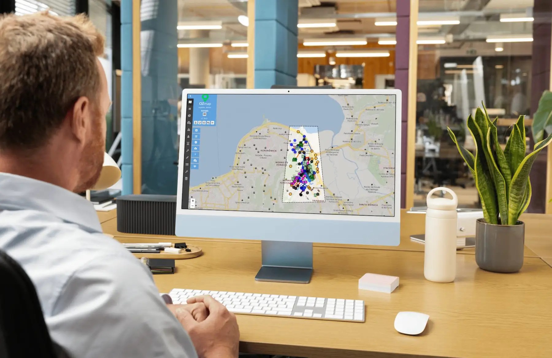 Homem analisando documentação de rede eficiente em computador com o Ozmap aberto em ambiente de escritório moderno