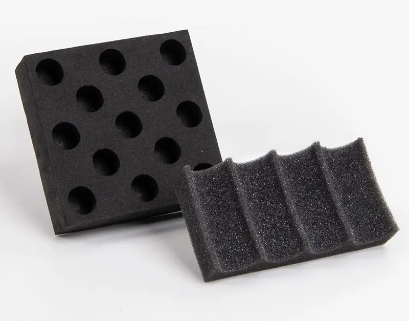black foam box inserts with various cutouts displayed together for protective product packaging use