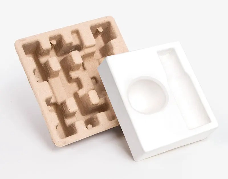 biodegradable molded pulp inserts and a white molded insert displayed for sustainable packaging use