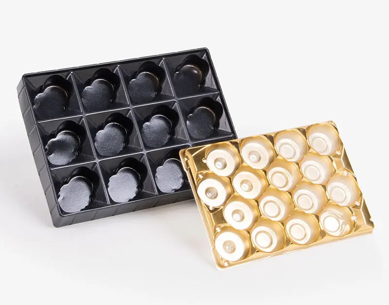 plastic thermoformed tray inserts in black and gold colors with molded cavities for product holding