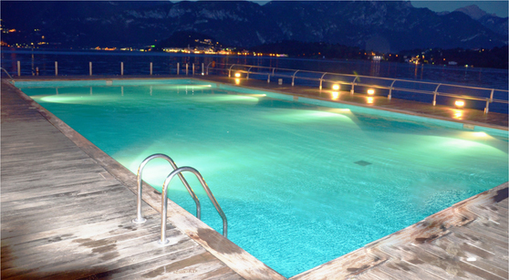 custom swimming pool design - night time lit swimming pool