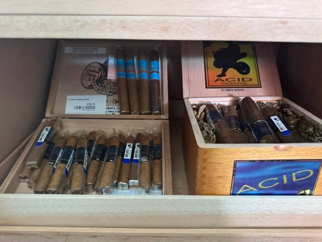 A picture of FAT bottom Betty cigars by deadwood and a selection of Acid Blondie and Layland cigars stored in a humidor in Pagosa Springs Colorado